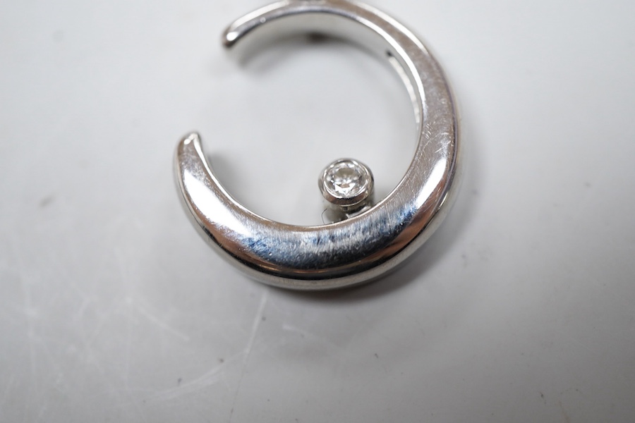 A diamond pendant, designed as a crescent moon accented with two collet-set brilliant-cut diamonds totalling approximately 0.20 carats, one sliding up and down the inner curve of the moon, length 2.6cm, mounted in platin